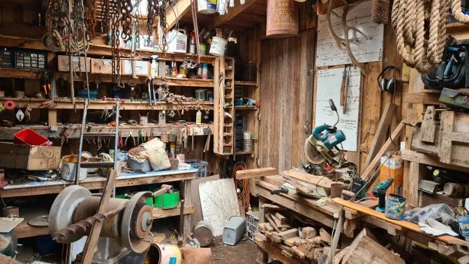 photo of an old, but well-used, woodworking shop filled with tools and scraps